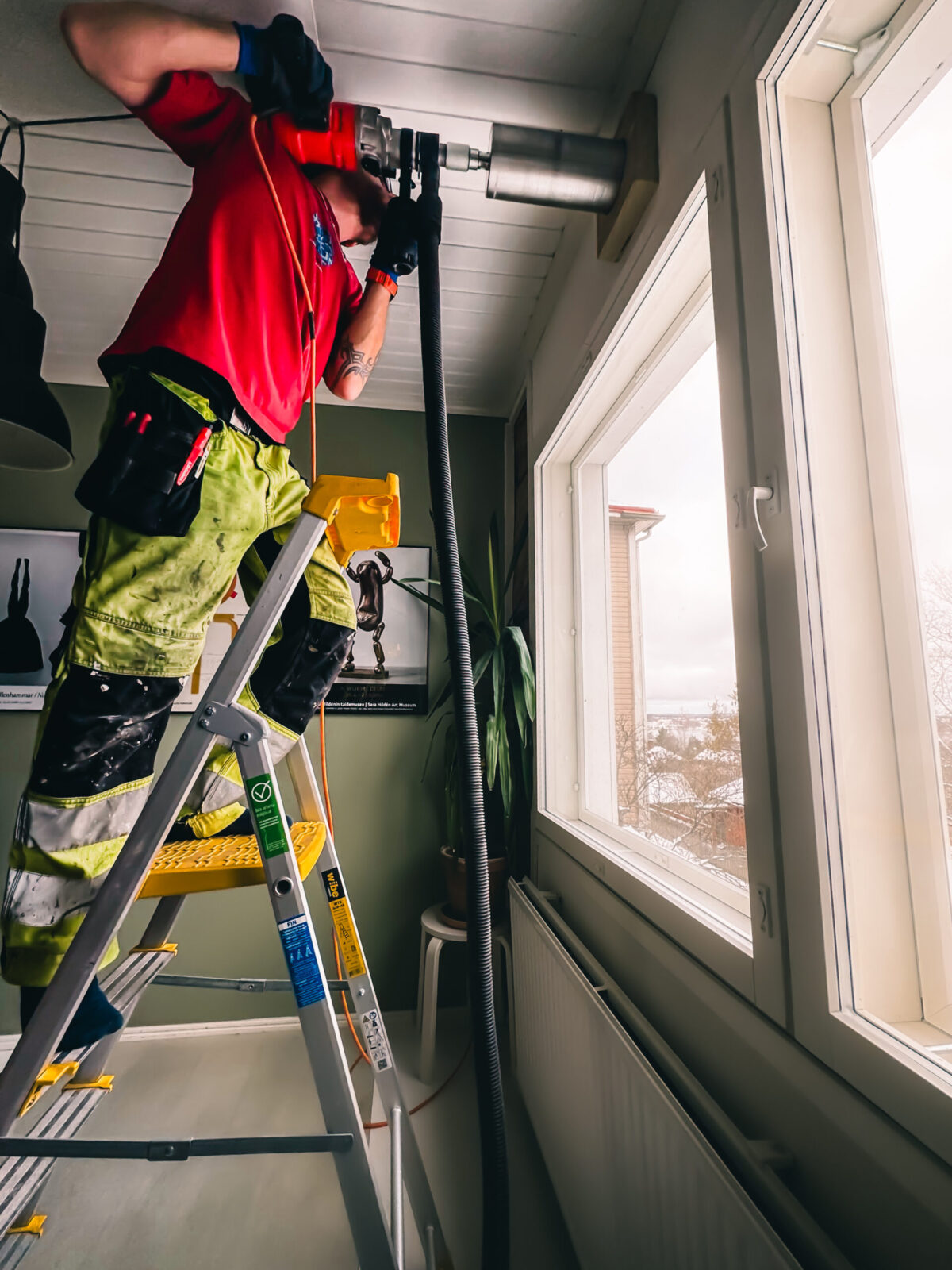 Mies poraa seinään reikää timanttiporalla – betonin poraus timanttiporakoneella