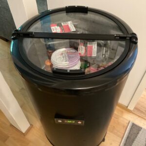 Pyöreä musta 50 litran juomacooleri lasikannella juhliin ja tapahtumiin. Coolerin sisällä näkyy juomia ja elintarvikkeita. Sopii juomien ja ruokien viilennykseen Helsingissä, Espoossa ja Vantaalla.